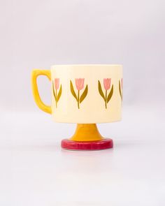 side view of top view of cream 10 oz ceramic mug with yellow handle, pink pedestal base and pink tulip print Pretty Ceramic Mugs, Ceramic Painted Mug, 60s Ceramics, Tulip Mug, Interior Objects, Scandinavian Home Decor, Espresso Mug, Clay Techniques, Colorful Pottery