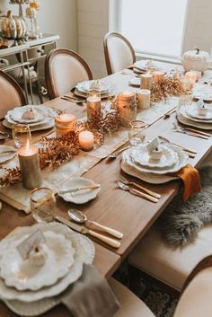 a dining room table is set with candles and dishes for thanksgiving dinner guests to enjoy