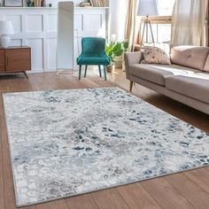 a living room filled with furniture and a rug on top of a hard wood floor