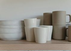 there are many white cups on the shelf