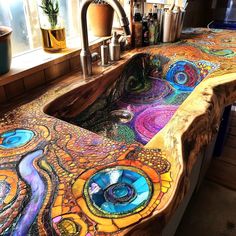 a sink made out of wood with colorful designs on the counter top and side panels