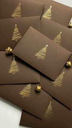 six brown cards with gold foil christmas trees on them