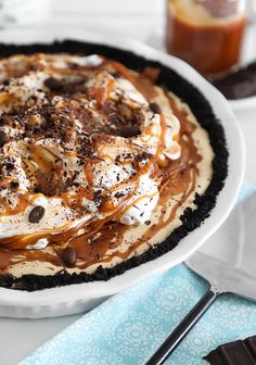 there is a pie on the table with chocolate and whipped cream in front of it