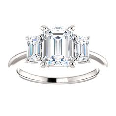 an emerald cut diamond ring with three baguets on the band and side stones