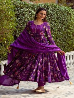 This Set Has a Anarkali, bottom and dupatta. Floral printed tier Anarkali set with hand embroided yoke. It is paired with matching chanderi foil print dupatta enhanced with fabric detailing and palazzo pants. Color: Purple Fabric: Anarkali - Cotton Silk Bottom - Shantoon Dupatta - Chanderi Product Details: Neck Type - Round neck Anarkali Length - 50 inches Bottom Length - 38-40 inches Sleeve Length - 22 inches Note: Available in other colors The product will be delivered within 2-4 weeks of orde Anarkali Purple Palazzo Set With Gota Work, Purple Anarkali Palazzo Set With Cutdana, Unstitched Gota Work Anarkali Set, Unstitched Maxi Length Anarkali Set With Gota Work, Purple Anarkali Palazzo Set In Chanderi, Festive Gota Work Palazzo Set Maxi Length, Anarkali Set With Cutdana In Mulmul, Fitted Cotton Silk Anarkali Set With Gota Work, Anarkali Style Purple Palazzo Set With Pallu