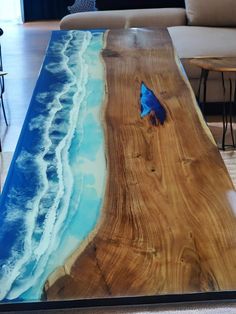 the table is made out of wood and has blue paint on it, along with an ocean scene