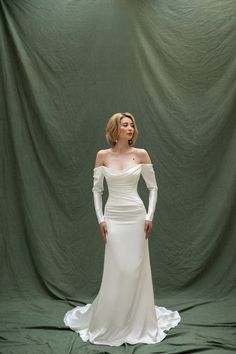 a woman in a white wedding dress posing for a photo with her hands on her hips