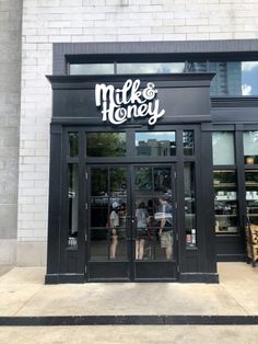 the entrance to milk and honey with people standing outside