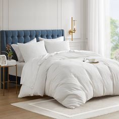 a bed with white sheets and pillows in a room