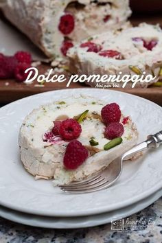 a piece of cake with raspberries on it and a fork next to it