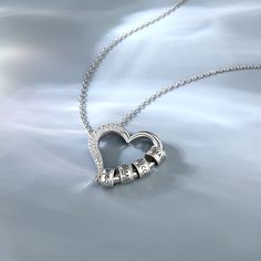 This sterling silver necklace's pendant, a hollow out heart clasp design, delicately crafted from pure silver. It's a beautiful symbol of love, friendship, and family. The hollow out heart clasp pendant allows you to customize the necklace by adding rings inscribed with the names of your loved ones. Each circle is a reminder of the special bond you share with each family member, a tangible expression of your love and appreciation. As you wear the heart necklace with your family name customized, Silver Charm Necklace With Heart Beads And Pendant, Silver Pendant Necklace For Anniversary Gift, Silver Pendant Necklace For Anniversary, Silver Pendant Name Necklace For Mom, Personalized Heart Necklace In Sterling Silver, Sterling Silver Heart Necklace With Round Pendant, Silver Sterling Silver Heart Necklace, Silver Heart Pendant Necklace With Heart Beads, Silver Necklace With Heart Pendant And Beads