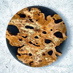 a wooden plate sitting on top of a cement floor next to a white and black wall