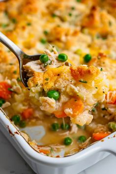 a spoonful of chicken pot pie casserole with peas and carrots on it