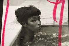 an old photo of a woman in the water with a red ribbon around her neck