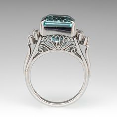 This gorgeous vintage ring is centered with one (1) emerald cut aquamarine that is set into a four-prong setting. On either side of the aquamarine are five (5) round brilliant cut diamonds that are prong set. The side galleries of the ring have ornate filigree designs. The ring measures 12.1mm at the top, rises 10.6mm above the finger, tapering to 2.9mm wide and 1.6mm thick at the base of the shank. It is currently a size 6 with a knife edge shank. Elegant Emerald-cut Topaz Rings, Aquamarine Brilliant Cut Diamond Ring For Formal Occasions, Octagon Emerald Ring With Diamond Accents For Formal Events, Formal Aquamarine Diamond Ring With Brilliant Cut, Octagonal Emerald Ring With Diamond Accents For Formal Events, Luxury Aquamarine Octagon Ring, Formal Octagon Emerald Ring With Diamond Accents, Luxury Octagon Aquamarine Ring, Luxury Aquamarine Diamond Ring With Prong Setting