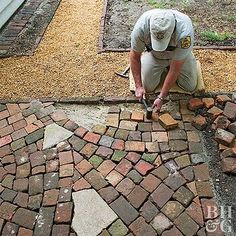 a man laying bricks on the ground