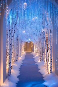 an archway is decorated with snow and lite up by lights in the wintertime