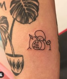 a small tattoo on the arm of a person with a potted plant behind it