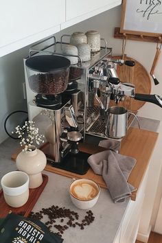 a coffee maker sitting on top of a counter next to some cups and saucers