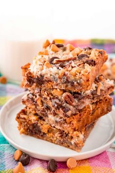 three dessert bars stacked on top of each other with chocolate chips and almonds around them