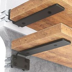 two wooden beams are attached to the ceiling with brackets on each side and one beam is missing