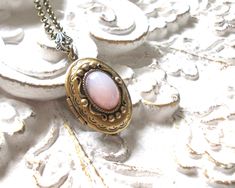 Beautiful brass photo locket necklace in antique bronze with a rose quartz cabochon. This would make a lovely present... The locket is made of brass and oxidized brass and has an antique bronze brass rolo chain. Cabochon size 10 x 14 mm., the locket measures 2.3 x 3 cm. (0.9 x 1.2 inches) The chain is approximately 50 cm. (19.6 inches) For a different length please contact us. The oxidized brass components are made in the USA, most pieces are stampings made of antique dies from the 19th century. Steampunk World, Locket Necklace Vintage, Brass Components, Photo Locket Necklace, Oxidized Brass, Bronze Patina, Photo Locket, Rolo Chain, Necklace Vintage