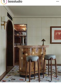 two stools sit in front of a bar with polka dots on the floor and walls