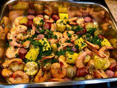 a pan filled with shrimp, corn and potatoes