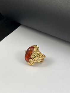 Handmade ring made entirely by hand with figures of Puttini in gilded silver Romantic style with a Baltic Amber cabochon in the center Adjustable one-piece size Dimensions Cm 3,x3,2 Inches 1.38x1.26 The item shipped will be that of the photo because it is a UNIQUE PIECE. A handmade jewel is unique and unrepeatable: it could be reproduced or proposed in other variations, but it will never be identical to another piece Produced in my workshop in the heart of Tuscany, the item is shipped from FLORE Formal Gold Cabochon Signet Ring, Oval Gold-plated Rings Hallmarked, Oval Gold Plated Rings Hallmarked, Gold Cabochon Signet Ring Fine Jewelry, Elegant Amber Cabochon Ring, Gold Sterling Silver Jewelry With Cabochon, Gold Signet Ring With Cabochon, Formal Amber Ring Jewelry, Elegant Handmade Yellow Gold Engraved Ring