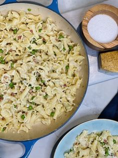 a pan filled with pasta and peas on top of a counter next to other dishes