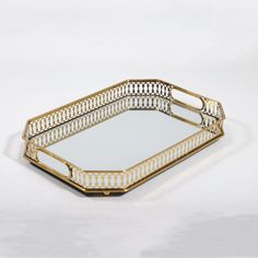 a gold tray with an intricate design on the bottom and sides, sitting on a white surface