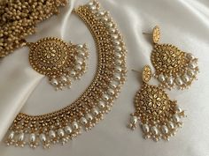 the necklace and earrings are adorned with pearls