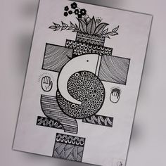 a black and white drawing of a vase with flowers on it's side, sitting on a piece of paper