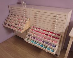 a shelf filled with lots of different types of crafting supplies on top of a wooden floor