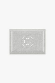 a business card with the letter b in white on a light grey background and an oval monogrammed border