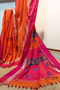 Elevate your style with our exquisite handloom pure cotton saree in a vibrant bright flame orange hue, adorned with a stunning fuschia pink temple woven border. This saree is a testament to fine craftsmanship, featuring intricate multicolor embroidery work reminiscent of the enchanting Kathiyawadi design, meticulously and neatly done on the fabric. In addition to its artistic flair, this saree is designed for both elegance and comfort. Crafted from pure, soft cotton, it offers a luxurious and comfortable drape, ensuring you look and feel your best on any occasion. To complete your ensemble, a matching blouse piece with intricate embroidery work is thoughtfully included. Experience the perfect fusion of tradition, artistry, and comfort with this exceptional pure cotton saree. Elevate your f Saree With Embroidery Work, Saree Blouse Design, Latest Saree Blouse, Multicolor Embroidery, Indian Handloom, Latest Saree, Diwali Special, Embroidered Saree, Navratri Special