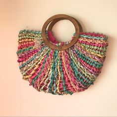 a multicolored bag hanging on the wall with a wooden ring in front of it