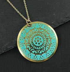 Turquoise and gold medallion necklace features a round gold disc embossed with an ornate design and colored with turquoise enamel. Pendant has a distressed feel with some dark areas on the pendant. This is part of its style. Pendant is 1 3/16 inches in diameter (30mm). Your choice of chain lengths - 16 or 18 inches. Chain is gold plated. Find more necklace styles here - https://www.etsy.com/shop/CharleneSevier?ref=hdr_shop_menu&section_id=10084290 Sign up for my newsletter! Copy and paste this link in your browser - http://eepurl.com/iSq7Wc ---------------------------------- PLEASE READ: This item is not intended for children where choking is a hazard. ---------------------------------- Bohemian Gold Coin Necklace With Round Pendant, Gold Bohemian Coin Necklace With Round Pendant, Blue Etched Round Jewelry, Blue Round Etched Jewelry, Patina Round Pendant Necklaces For Gift, Patina Round Pendant Necklace For Gift, Round Pendant Necklace With Patina For Gift, Turquoise Coin Pendant Jewelry As Gift, Handmade Turquoise Necklace With Round Gold Pendant