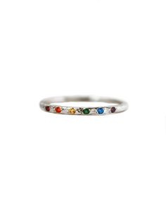 Let your inner rainbow shine and guide you through all of life's ups and downs. This gorgeous hand textured ring features a sparkling rainbow of gemstones. Delicate and comfortable to wear, this sterling silver rainbow ring is perfect for stacking with your favorite rings or even as a solo statement ring. A percentage of the proceeds from this ring go directly to organizations that support the LGBTQIA+ community globally Details:- A rainbow of sparkling genuine sapphire and topaz gemstones (exac Adjustable Rainbow Gemstone Ring, Rainbow Stackable Jewelry For Promise Ring, Rainbow Multi-stone Stackable Promise Rings, Rainbow Multi-stone Stackable Rings For Promise, Rainbow Sterling Silver Jewelry For Anniversary, Rainbow Sterling Silver Rings As Gift, Rainbow Gemstone Stackable Rings For Anniversary, Rainbow Sterling Silver Promise Ring, Multicolor Sterling Silver Stackable Rings