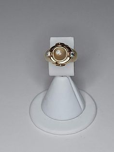 ITEM DESCRIPTION This is a vintage vermeil (gold over silver) ring.  It features a center glass moon glow cabochon.  On either side are cubic zirconia.  There are also cubic zirconia on the sides of the setting. See all photos please...they are part of the description. Markings/Stamps:  925 MEASUREMENTS: Size 7 Found in photos - please review all photos  **Due to age, there may be a small amount of age flaws not deemed to be worthy of noting...straw marks, bubbles, some scuffing, some particles. Heirloom Gold Opal Ring With Cabochon, Heirloom Gold Opal Cabochon Ring, Gold Cabochon Signet Ring Fine Jewelry, Gold Signet Ring With Cabochon, Classic Cabochon Moonstone Ring, Classic Round Cabochon Moonstone Ring, Gold Dome Ring With Cabochon For Anniversary, Heirloom Style Gold Opal Ring With Bezel Setting, Heirloom Gold Opal Ring With Bezel Setting