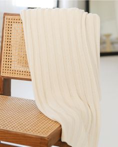 a white blanket draped over a wooden chair