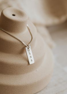 We updated our origina Mama Necklace to a shorter more modern bar design and added square pendant add-ons for the initials of your favorites. She’s still simple and minimal and full of very special meaning. Rectangle pendant measures 16mm long and is hand-stamped in a tiny uppercase block font. Bar is lightly brushed with steel wire for a matte finish. Our 6x9mm discs are hand-stamped with one heart or one initial per disc in an uppercase sans-serif font. Discs are suspended from a 16" or 18" de Modern Bar Design, Everyday Wear Jewelry, Block Font, Unique Silver Jewelry, Vertical Bar Necklace, Mama Necklace, Rectangle Pendant, Vertical Bar, Diamond Choker