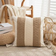 a white and brown pillow sitting on top of a floor next to a basket filled with pillows