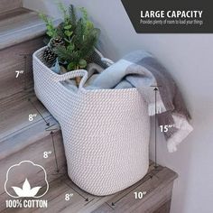 a white basket with plants in it sitting on some stairs