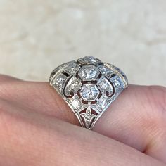 a close up of a person's hand with a diamond ring on their finger