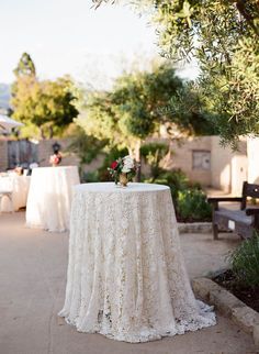 the table is set up outside for an outdoor wedding reception with white linens and flowers