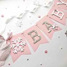 a pink and silver happy birthday banner with snowflakes on it's side