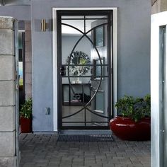 an open door leading to a room with potted plants on the outside and inside