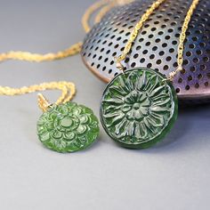 Unique, carved gemstone medallions star in these  gold filled necklaces. Made with delicate woven chain these necklaces feature unique, carved with beautiful floral designs, coin shaped, green Antigorite serpentine. Four available, two with  19mm medallions (options A and B) and two with 25mm medallions  (Option C and D).  Each one of these necklaces looks stylish and elegant, each makes make a statement. These necklaces are to be purchased separately.  Completed with gold filled, lobster claw c Carved Yellow Gold Amulet Jewelry, Spiritual Carved Medallion Necklaces, Carved Gold Round Pendant Jewelry, Gold Carved Round Pendant Necklace, Elegant Carved Pendant Necklace, Elegant Carved Round Pendant Necklace, Carved Yellow Gold Necklace, Handmade Yellow Gold Jade Necklaces, Spiritual Carved Medallion Jewelry