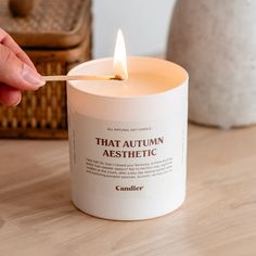 a person lighting a candle on a table